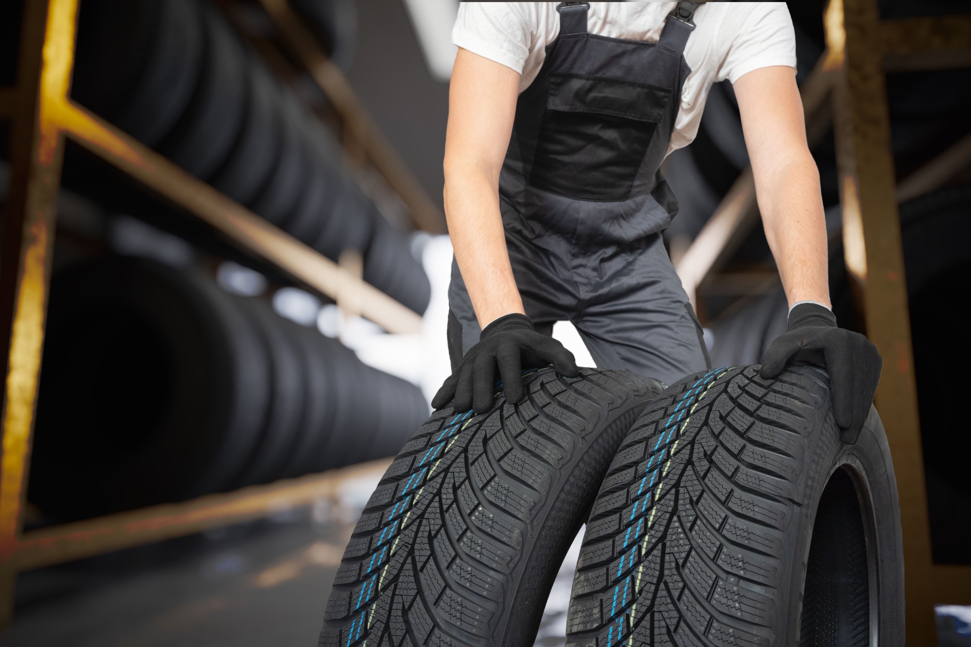 Car mechanic is changing tires for new ones.