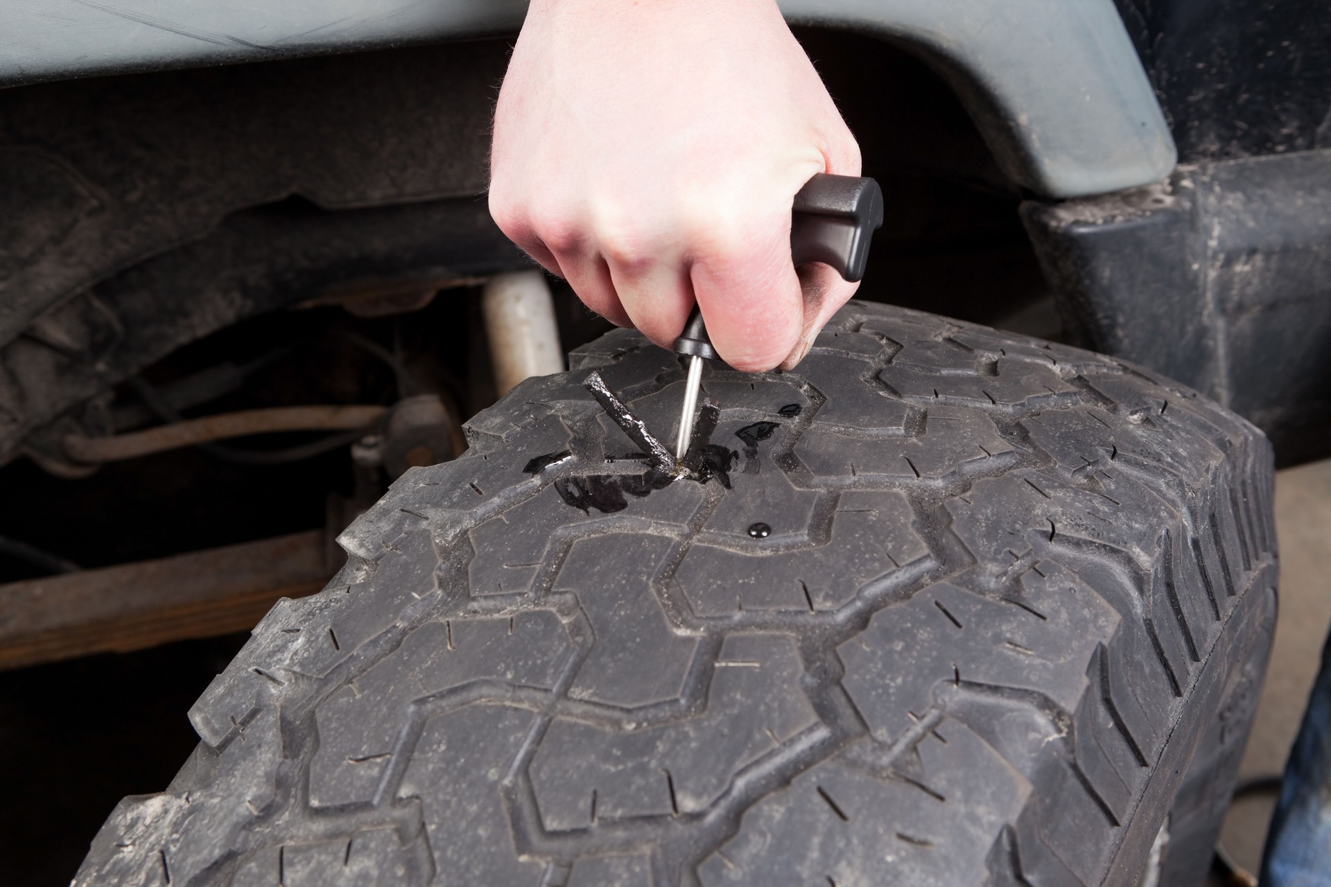 Mechanic Installing Rope Patch to Repair Tire Puncture